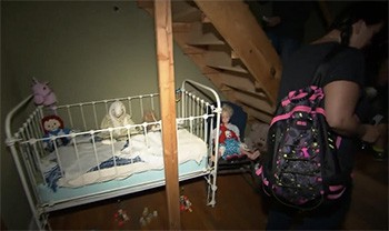4 Lessons You Learn While Trapped In A Haunted House (For Work) - a bunch of creepy haunted dolls in a crib