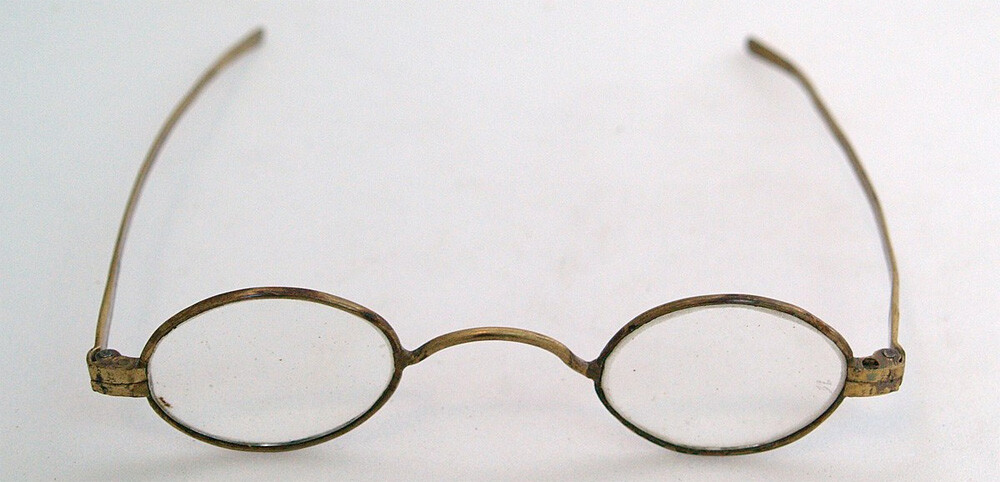 One pair of steel-rimmed glasses in wooden case