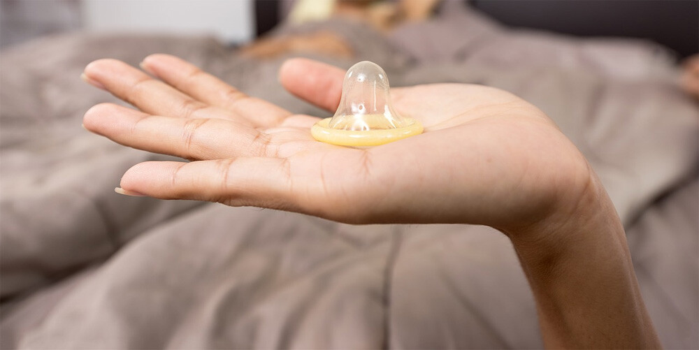 woman holding condom. 