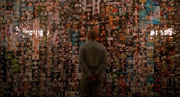 Sy in front of a wall of pictures
