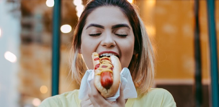 Woman eating hot dog